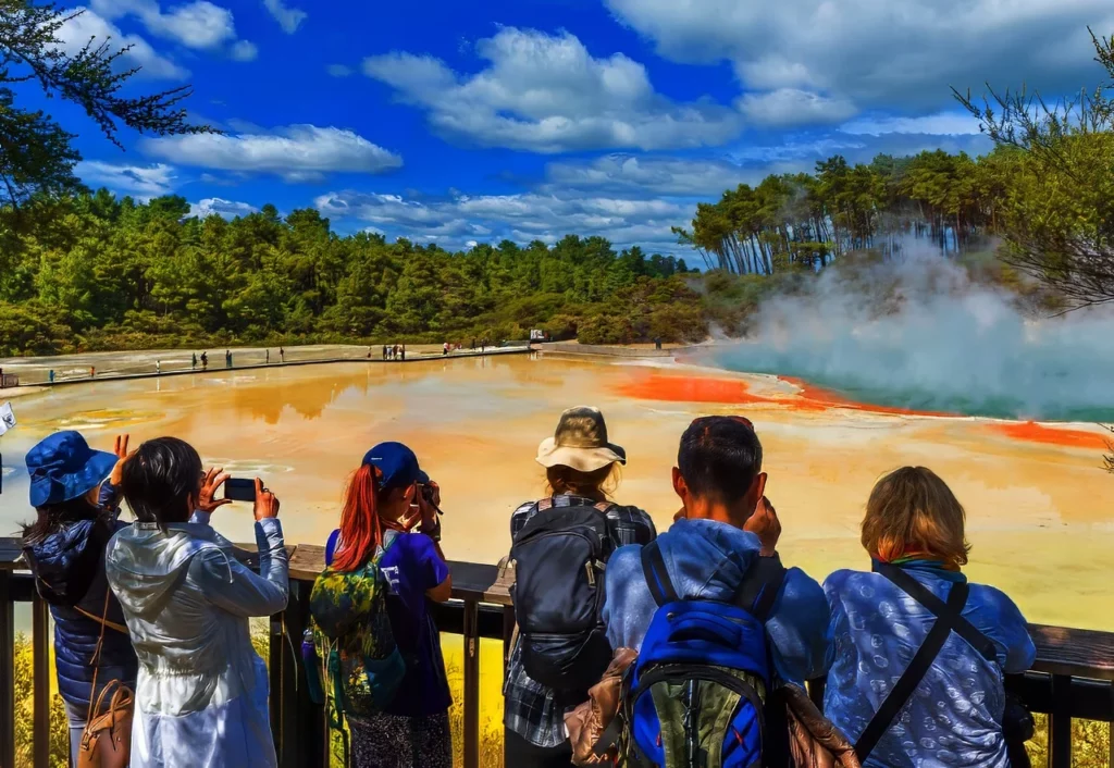 Visitors taking pictures of a geothermal pool in Rotorua, one of the best things to do in New Zealand.