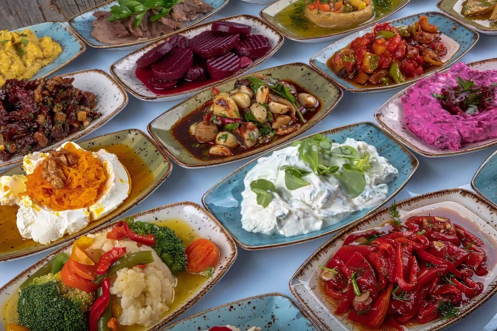 Turkish appetizers in colorful plates on meze table, samples of Turkey's food and drink scene.
