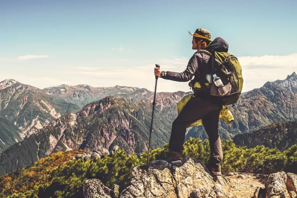 A hiker atop a mountain looking at the Alps in Nagano, one of the best specialty tours in Japan.